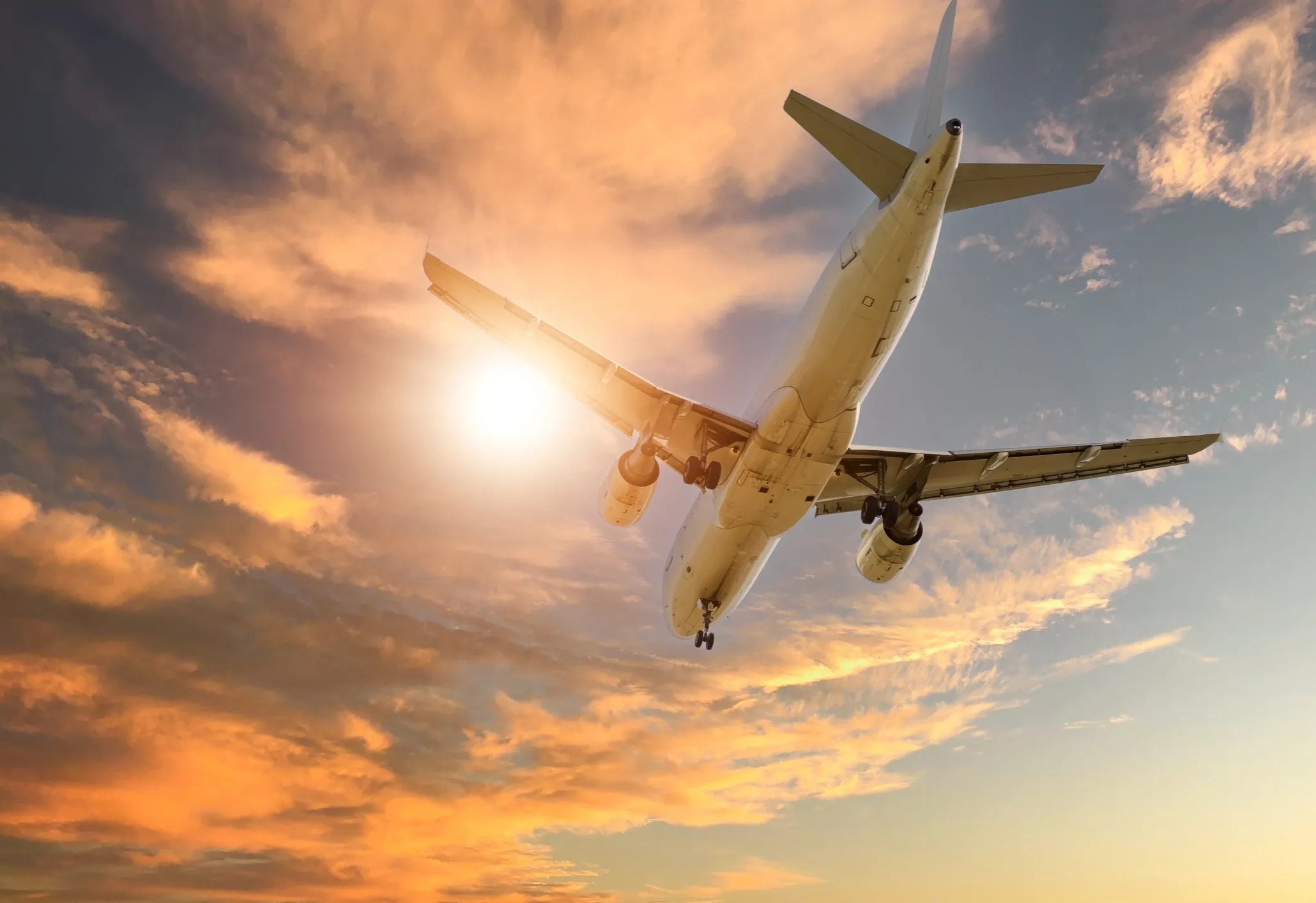 Commercial aircraft flying against dramatic sky